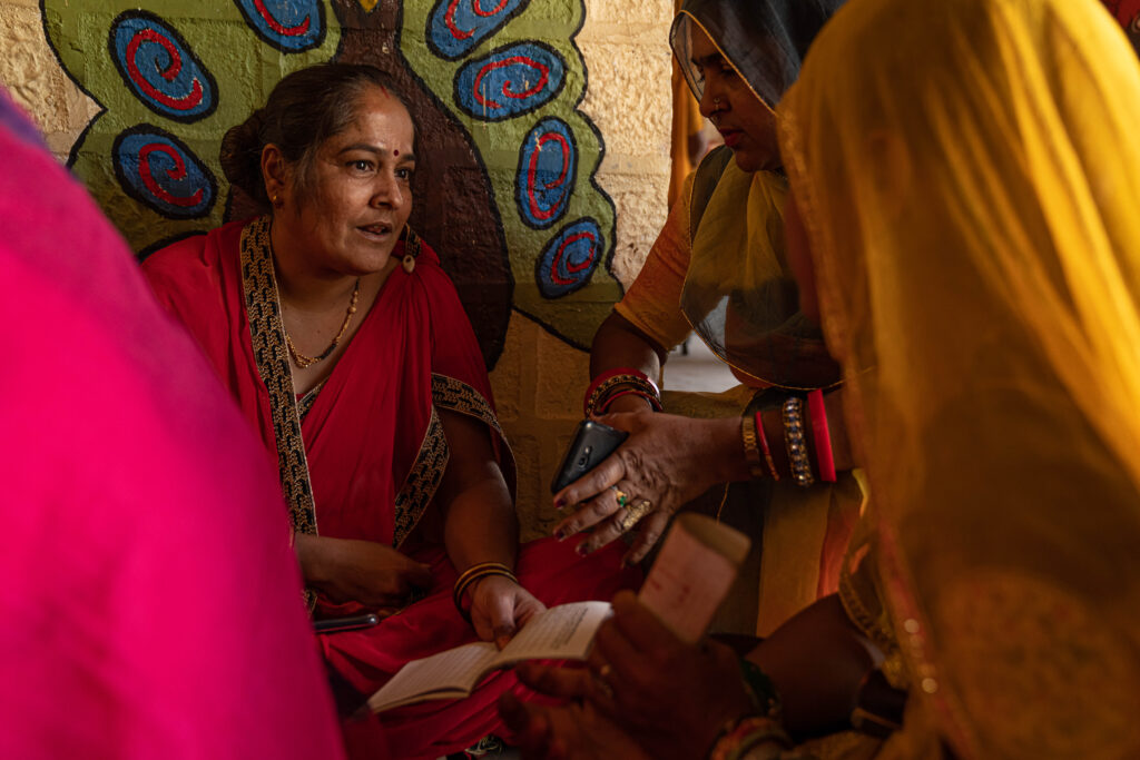 A woman deep in conversation with two other women inside the Sambhali Trust education center.