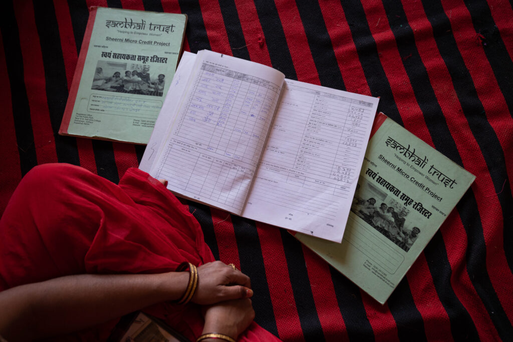 A woman looking over the Sambhali micro-credit program record keeping books.