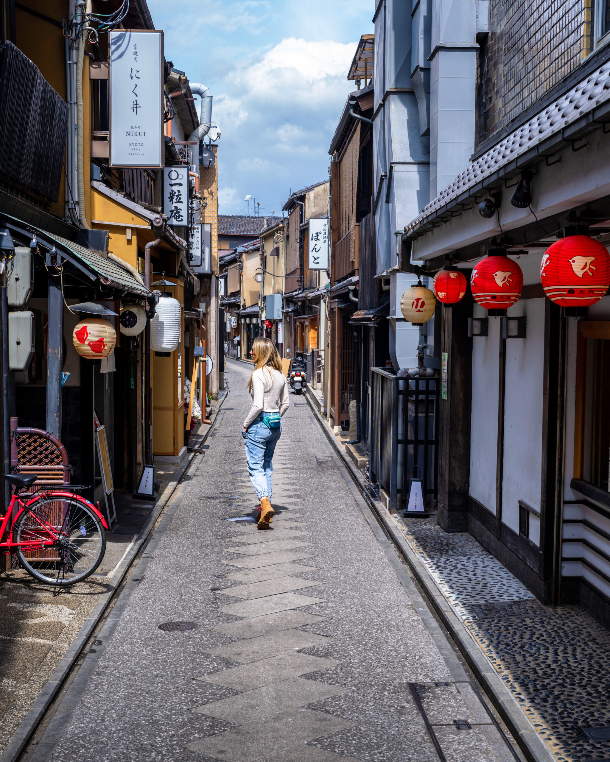 A woman wanders an empty side street in Kyoto, Japan.
