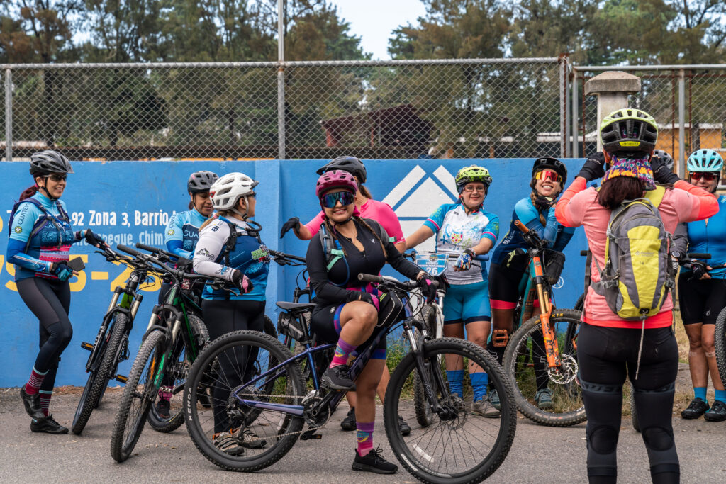A female cyclist smiles at the camera as she's lined up amongst a group of women at the start line of the World Ride travesia in Guatemala.