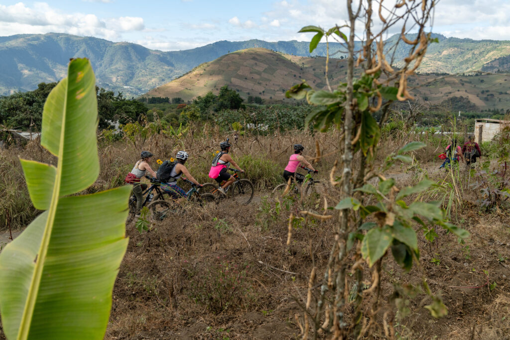 Four women bike through a coffee farm in the foothills of Antigua, Guatemala.
