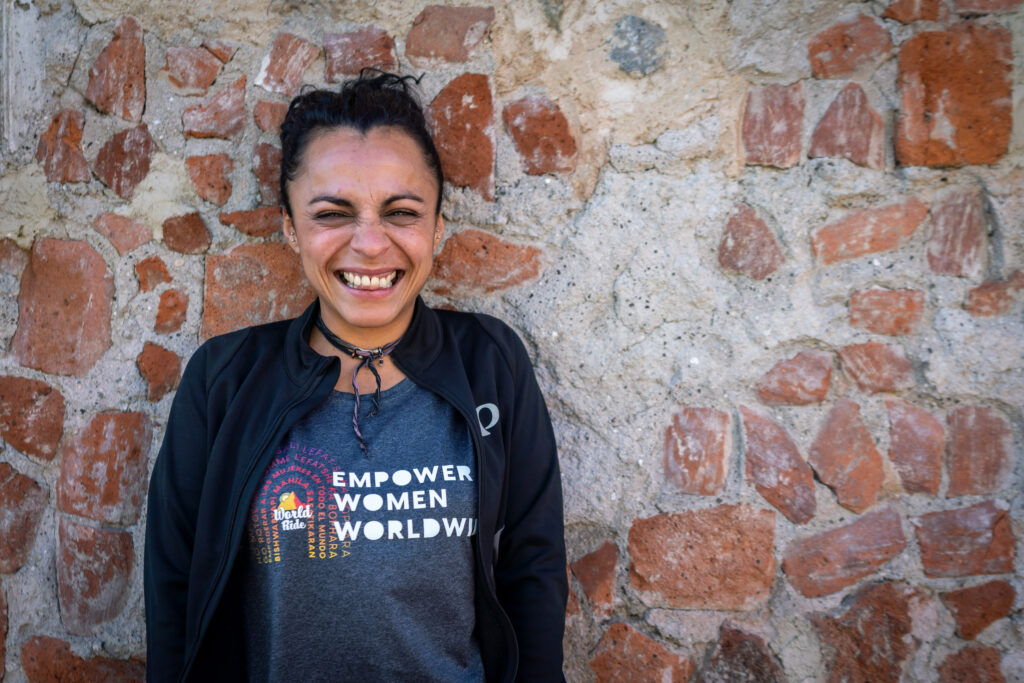 Christa Castillo smiles wide while wearing a World Ride tshirt that says Empower Women Worldwide.