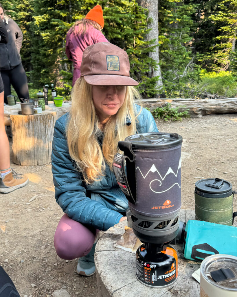 a backpacker using a jetboil stove to cook a meal instead of a campfire